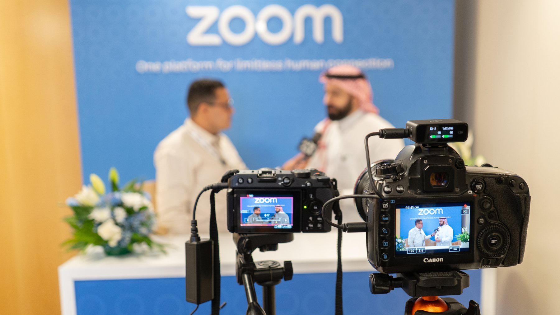 Isuru Marasinghe directing a two-camera booth interview for Zoom at a technology event